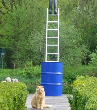 Skulptur mit blauem Fass, Leiter und Gummistiefeln